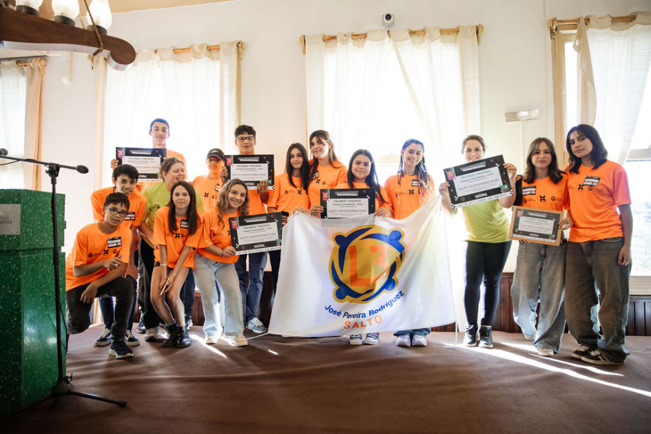 Estudiantes y docentes en escenario, con su reconocimiento.