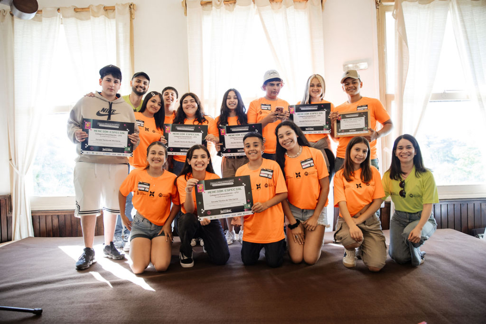 Estudiantes y docentes en escenario, con su reconocimiento.