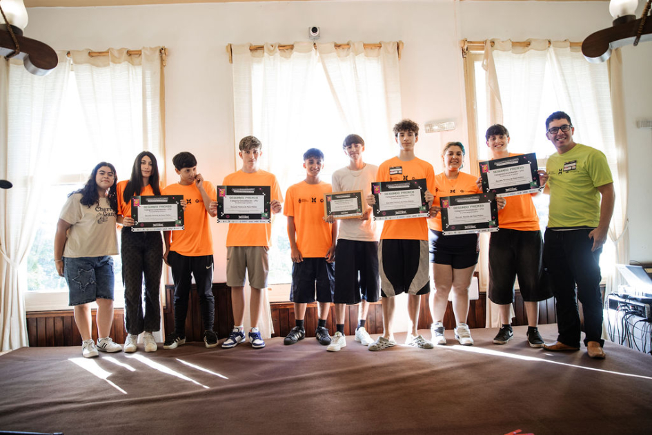 Estudiantes y docentes en escenario, con su reconocimiento.