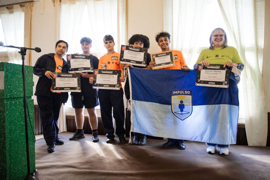 Estudiantes y docentes en escenario, con su reconocimiento.