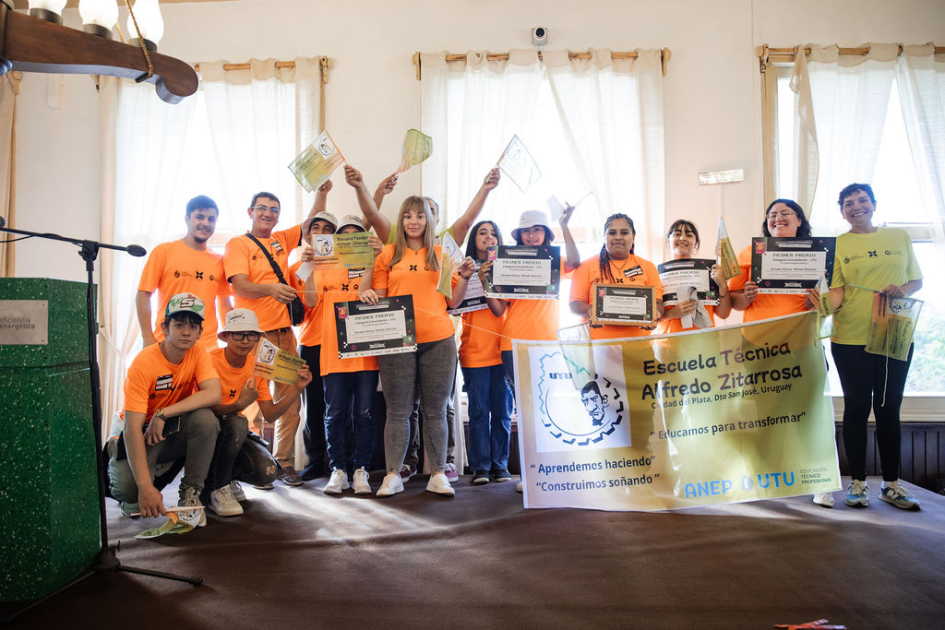 Estudiantes y docentes en escenario, con su reconocimiento.