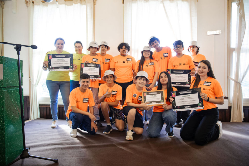 Estudiantes y docentes en escenario, con su reconocimiento.