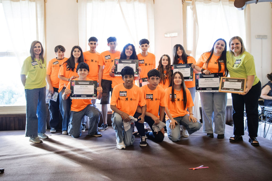 Estudiantes y docentes en escenario, con su reconocimiento.