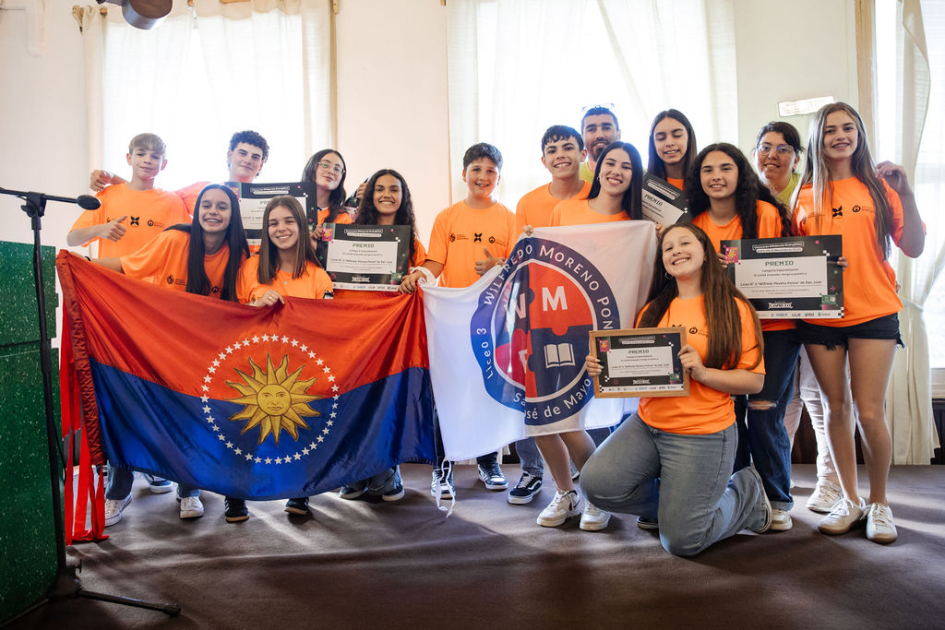 Estudiantes y docentes en escenario, con su reconocimiento.