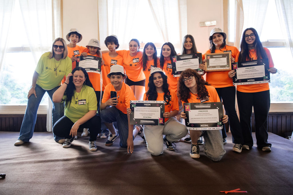 Estudiantes y docentes en escenario, con su reconocimiento.