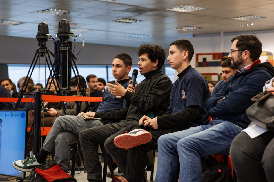 Estudiantes, sentados, escuchan un testimonio