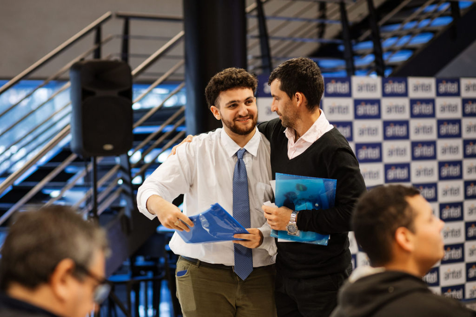 Estudiantes de pie, sonriendo y caminando, previo a su participación