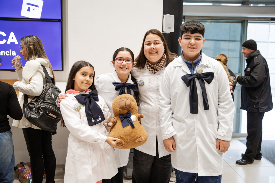 Estudiantes y maestra de escuela de Minas de Corrales, de pie con su mascota carpincho