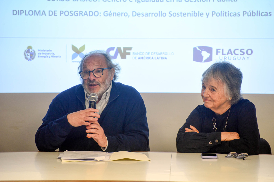 El subsecretario Daniel Olesker hizo uso de la palabra Olesker habla, sentado; a su lado, Beramendi, detrás, pantalla