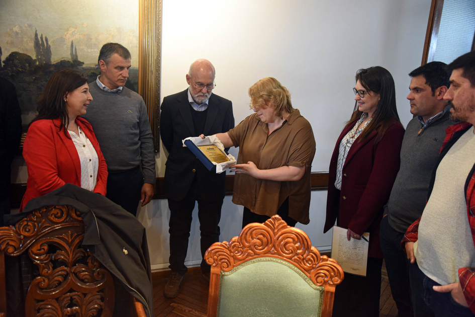 CUFMA entregó una placa de reconocimiento a la directora de Dinapyme, Ximena Cidrás Directora Cidrás, de pie, mira placa de reconocimiento que le entregó CUFMA