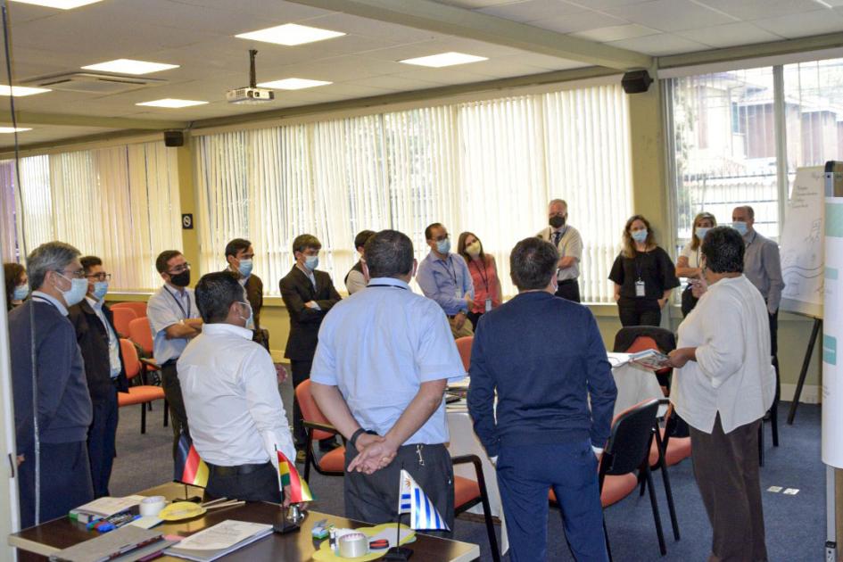 Plenarias en que se discutieron las actividades Muchas personas, de pie, dialogan en una sala iluminada