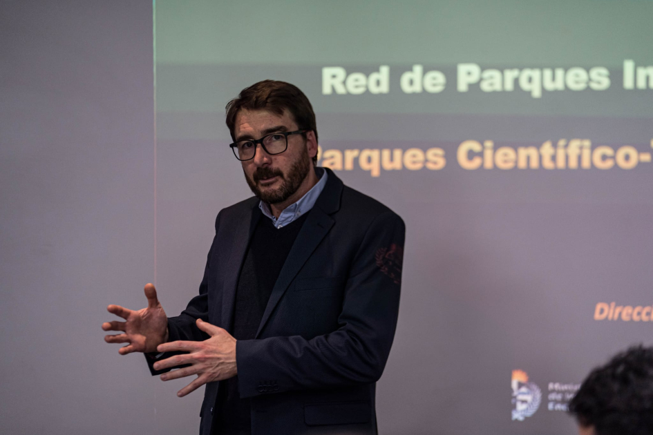 Director Míguez habla de pie; detrás, una proyección