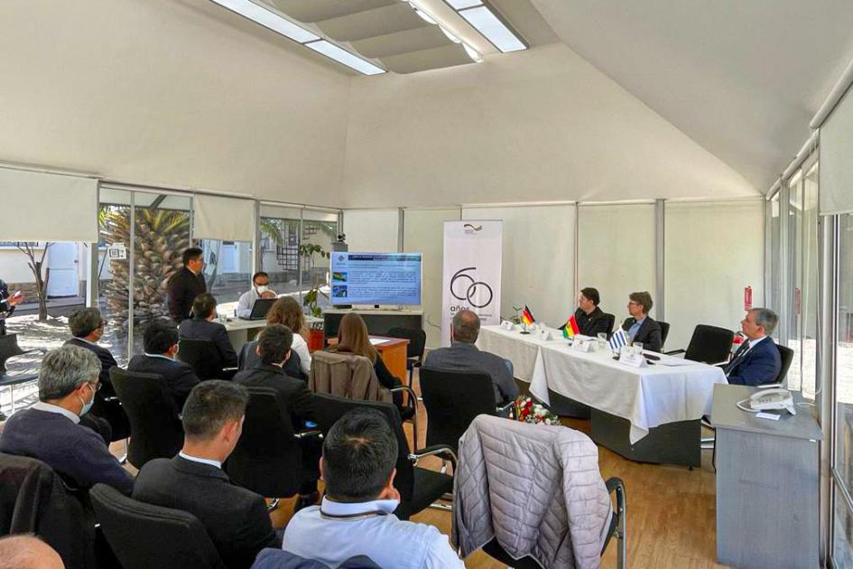 Presentación del MHE en el acto protocolar de cierre Varias personas escuchan a otras, sentadas en una mesa de autoridades