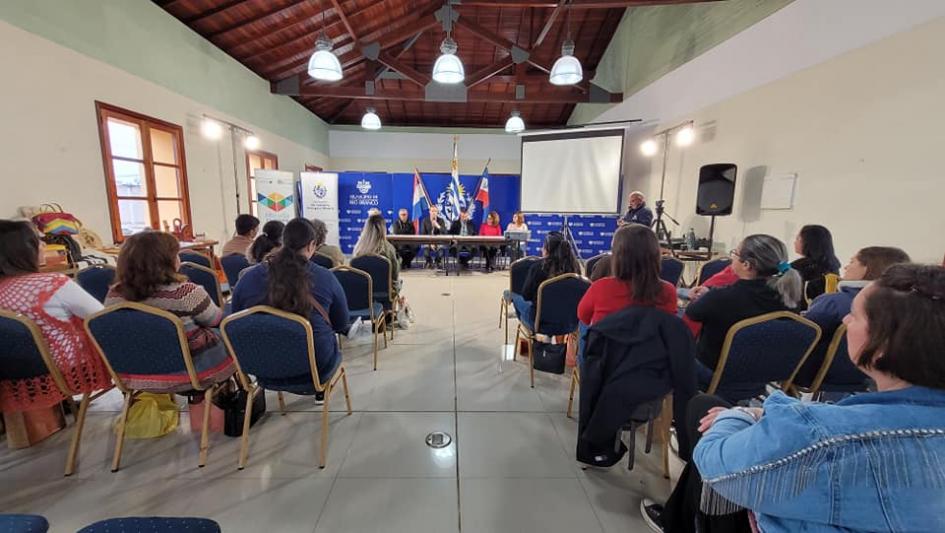 Sala con varias personas, vistas desde atrás.