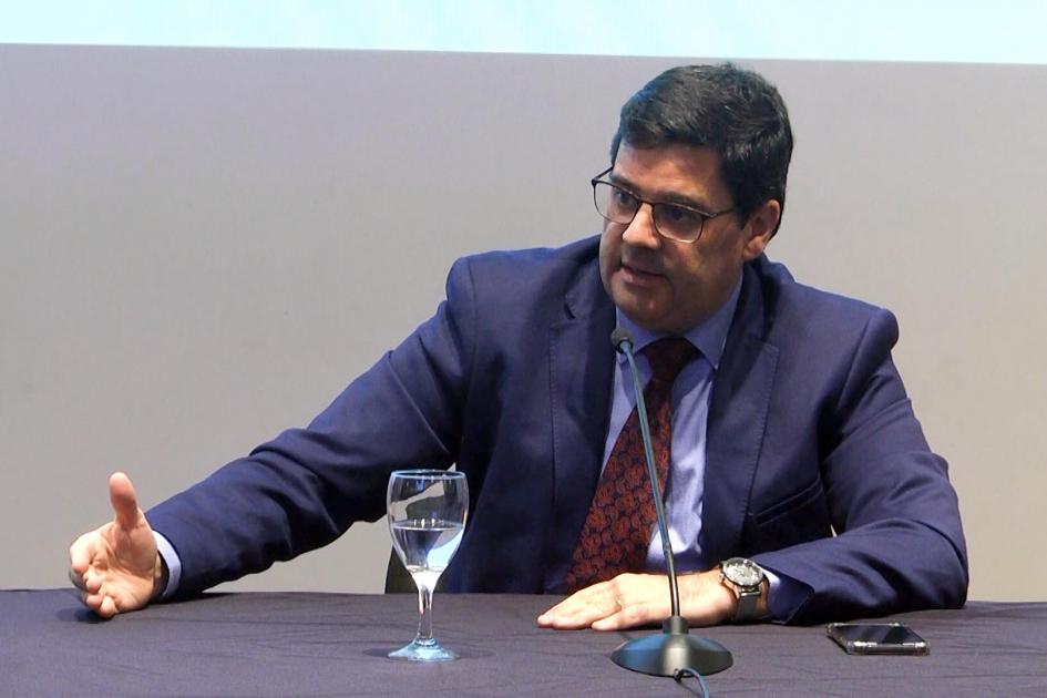Director nacional de Energía, Fitzgerald Cantero Habla frente a un micrófono el director Fitzgerald Cantero; está en una mesa que tiene una copa