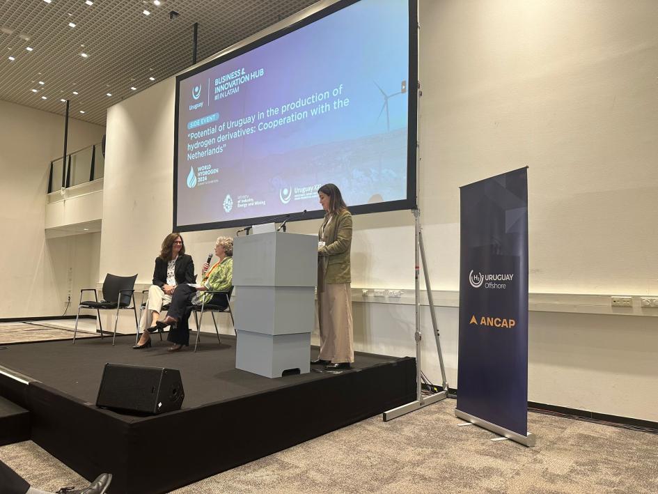 La ministra participó de un side event dedicado a Uruguay La ministra, sentada junto a otra mujer; a su lado, una mujer en un atril; arriba, pantalla