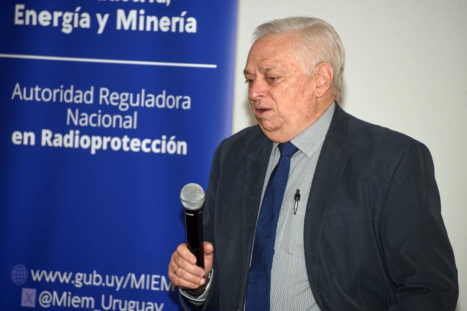 Experto del OIEA, Luis Jova, durante la inauguración Un hombre habla con un micrófono junto a un banner institucional azul