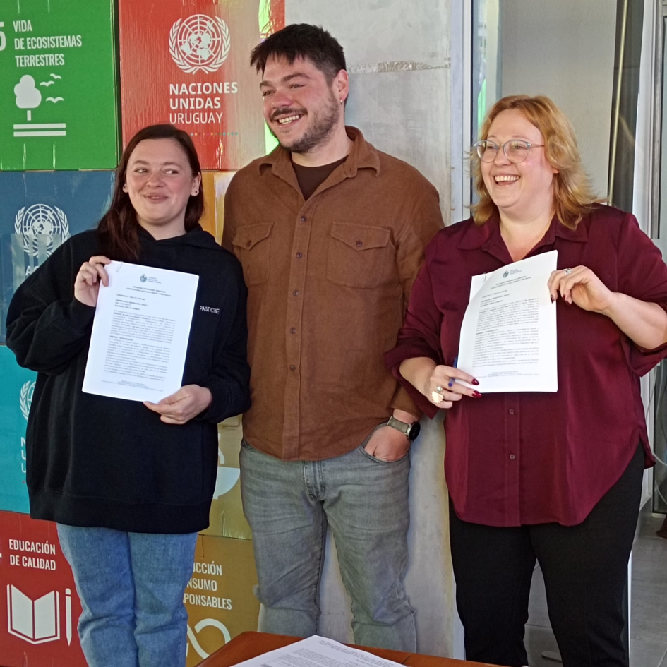 Adjudicataria y adjudicatario de Transforma Territorio Región Este, Rocha Directora Cidrás y mujer sostienen papeles, junto a un hombre