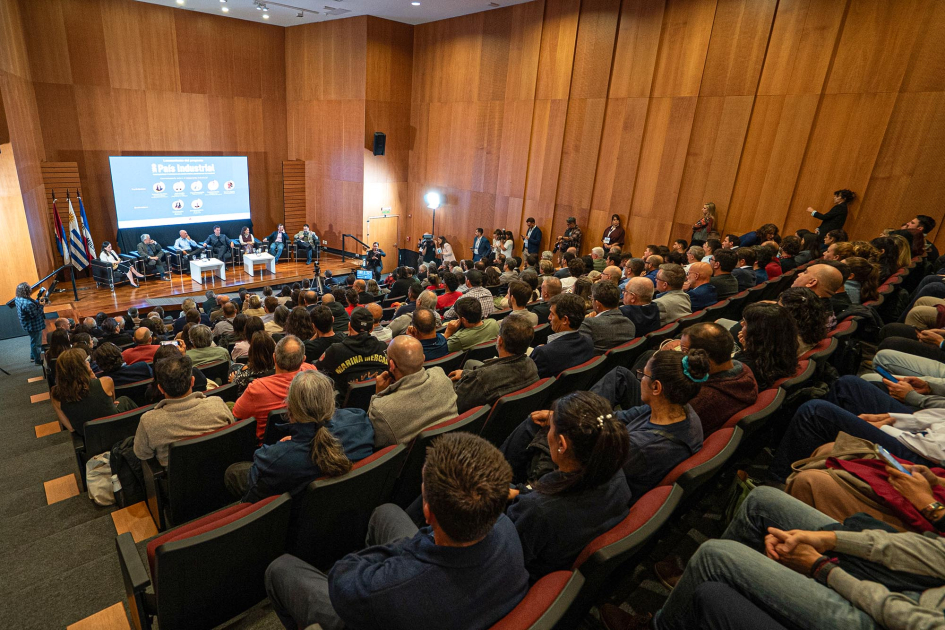 Auditorio completo; al fondo, escenario con pantalla