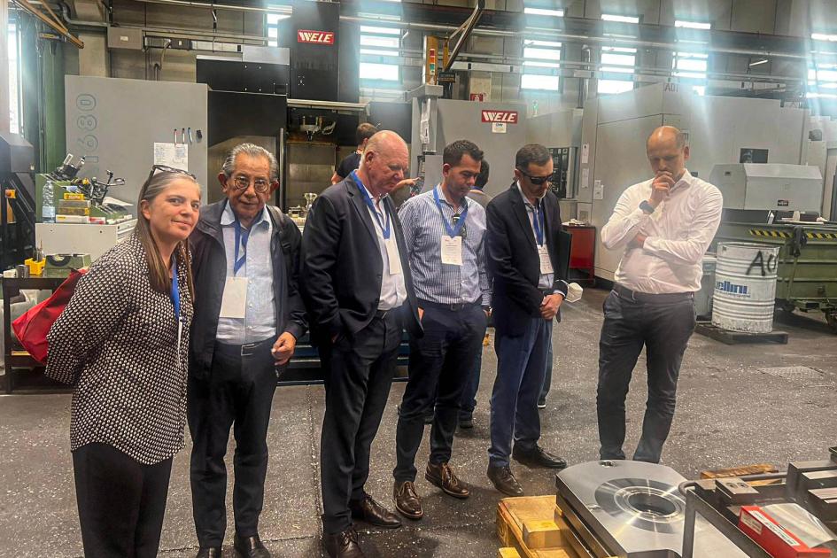 Recorrida por Verdelli Verri, de pie, junto a varias personas, en el interior de la fábrica de Verdelli