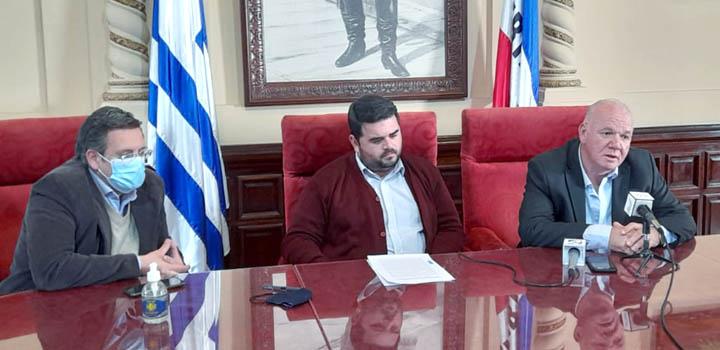Autoridades en la firma del convenio; detrás se ven banderas y el fragmento de un cuadro de Artigas. Autoridades en la firma del convenio; detrás se ven banderas y el fragmento de un cuadro de Artigas