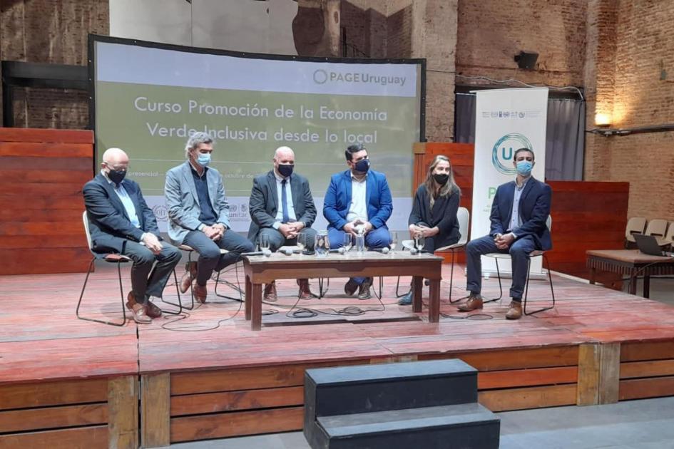 Mesa de autoridades en taller presencial de PAGE en Paysandú; frente a ellos hay una mesa ratona