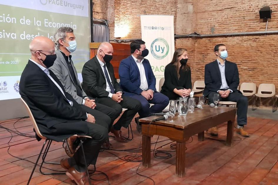 Mesa de autoridades en taller presencial de PAGE en Paysandú; frente a ellos hay una mesa ratona