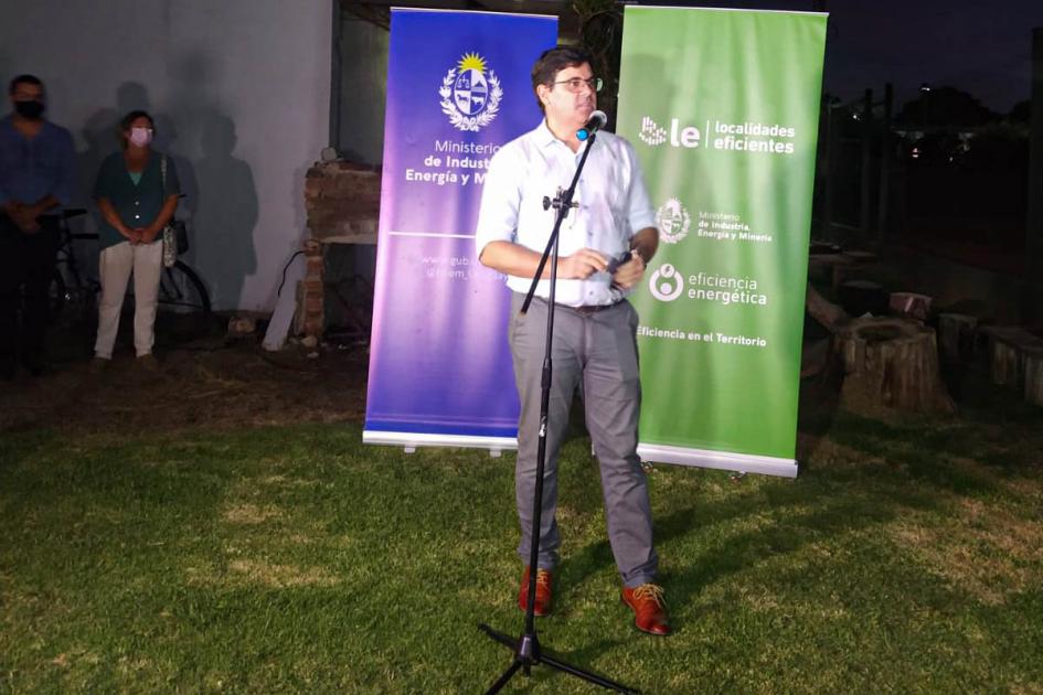 Director nacional de Energía, Fitzgerald Cantero, en Nueva Helvecia Director Fitzgerald Cantero habla frente a un micrófono; detrás están los banners del MIEM y LES