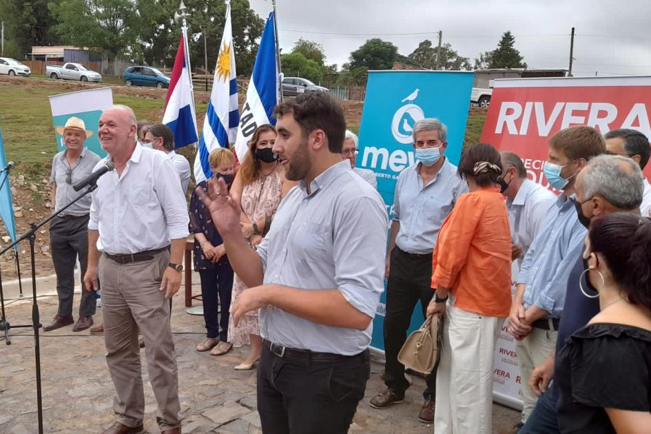 El ministro interino Verri hizo uso de la palabra Verri hace uso de la palabra, rodeado de personas; detrás se ven pabellones y banners