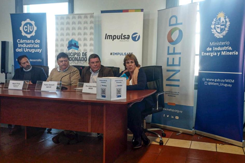 Ana Inés Antía, de Dinapyme, representó al MIEM en el evento Cuatro personas se ven en la mesa de autoridades; habla Ana Inés Antía; detrás hay banners