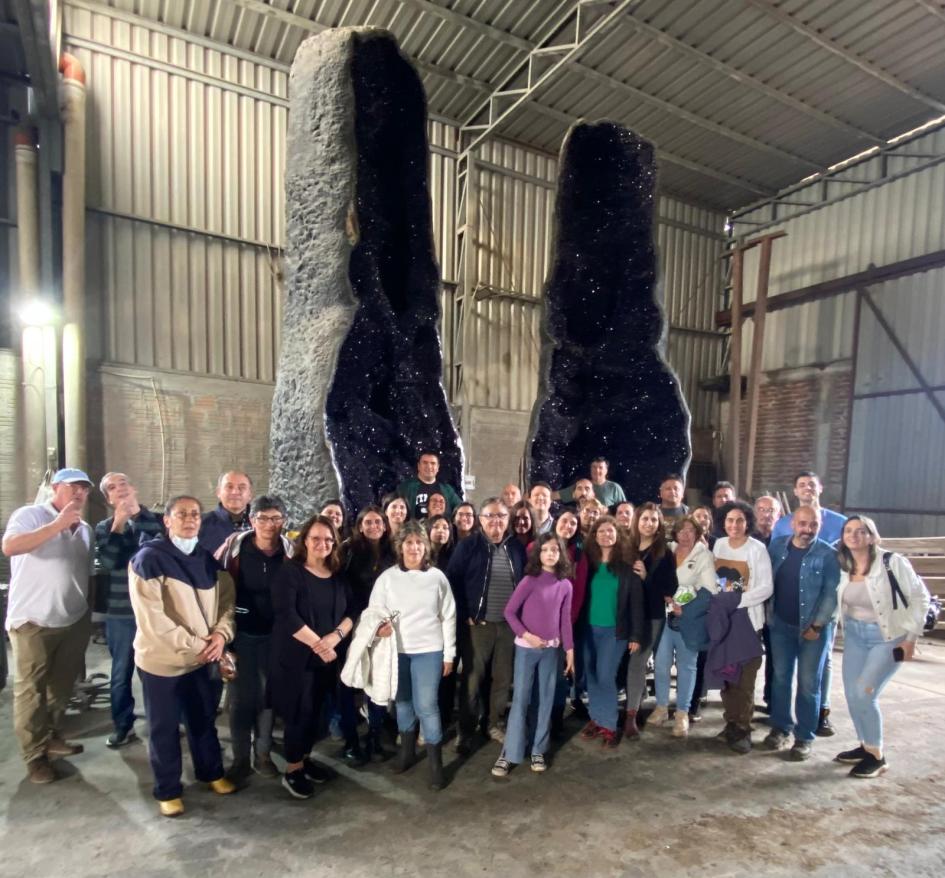 Dinamige visitó Artigas gracias a una invitación de AMINA Grupo de personas, dentro de un salón, frente a dos amatistas gigantes