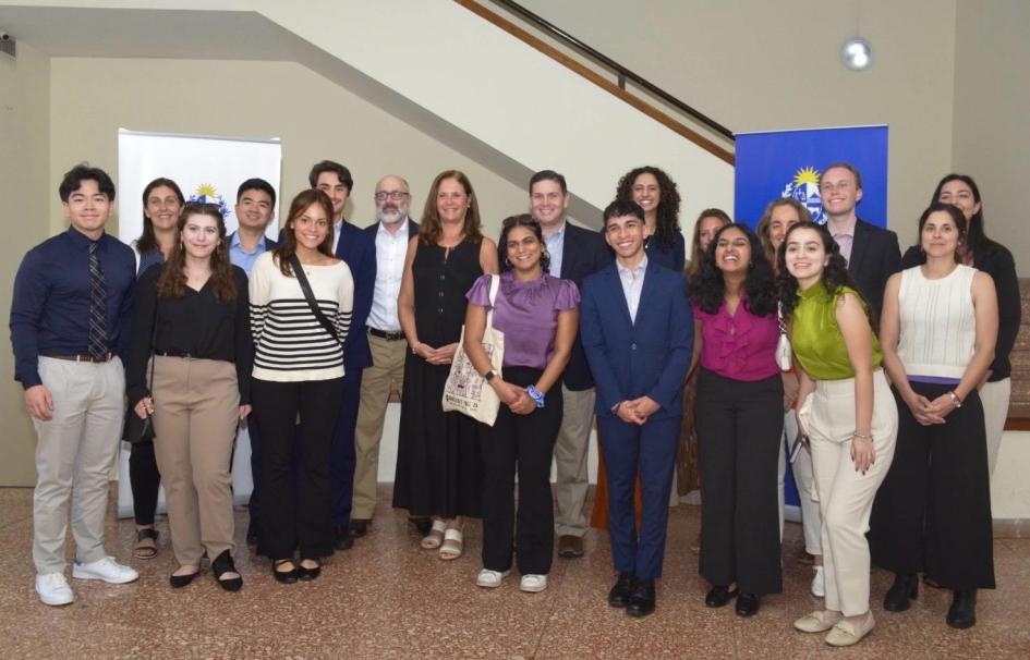 Estudiantes, docentes, ministra y equipo del MIEM posan junto a una escalera; hay banners del MIEM