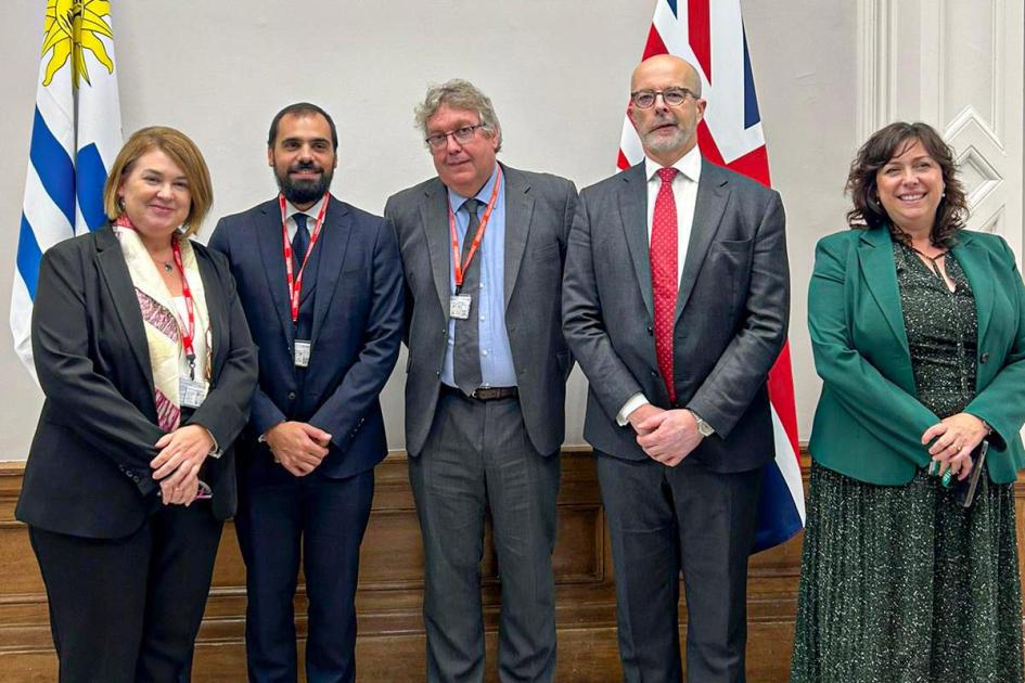 Autoridades uruguayas y británicas Autoridades uruguayas y británicas, de pie; detrás, banderas de ambos países