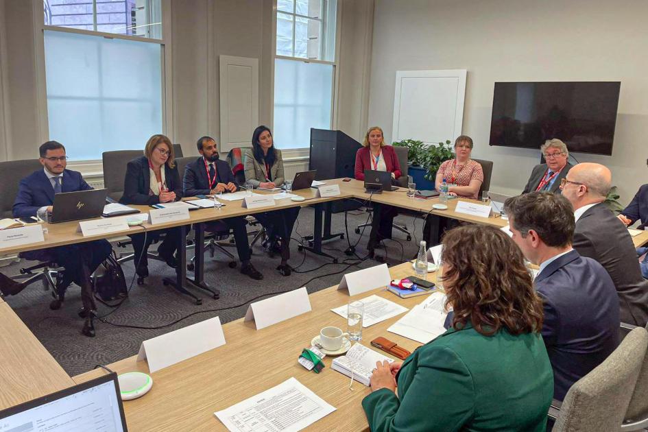 Delegaciones uruguaya y británica dialogan, sentados, en mesas dispuestas en "u"