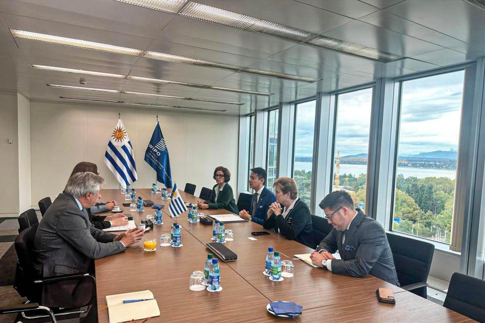 Ceremonia realizada en Ginebra, Suiza Delegaciones de Uruguay y de la OMPI, sentadas en una larga mesa; a los lados, ventanal y banderas