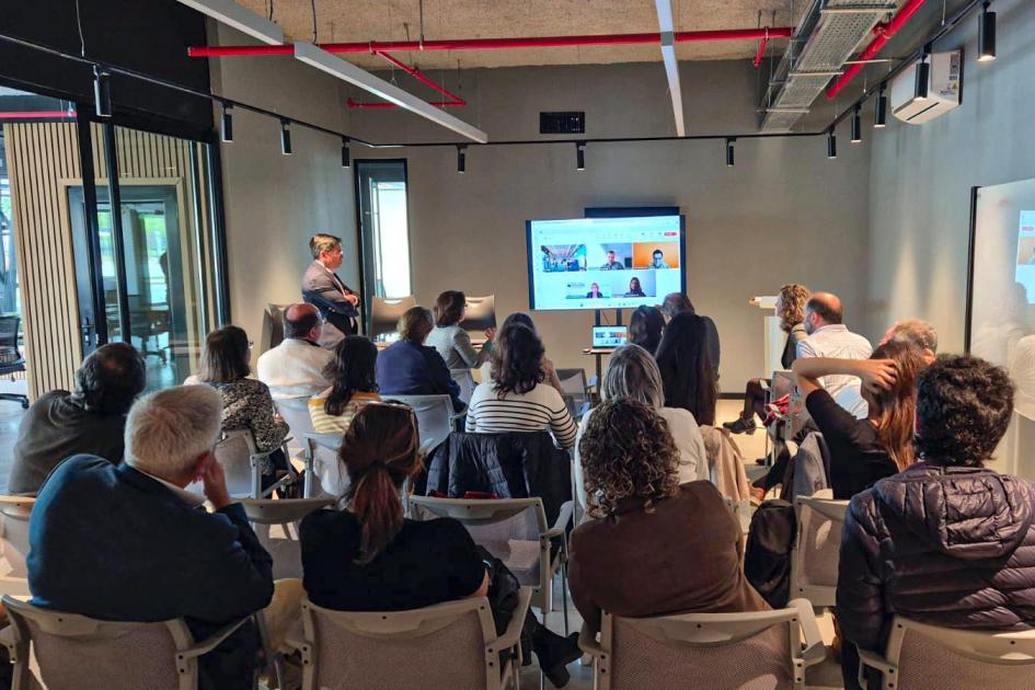 La actividad se desarrolló en el Campus de Innovación de Uruguay Innovation Hub Público, sentado y de espaldas; al fondo, disertantes y pantalla