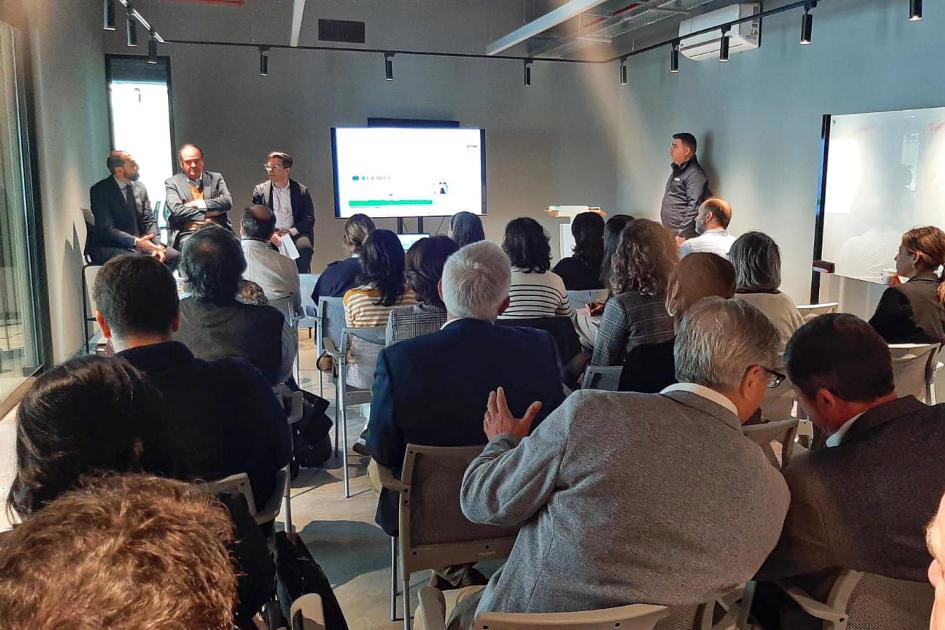 La actividad se desarrolló en el Campus de Innovación de Uruguay Innovation Hub Público, sentado y de espaldas; al fondo, disertantes y pantalla