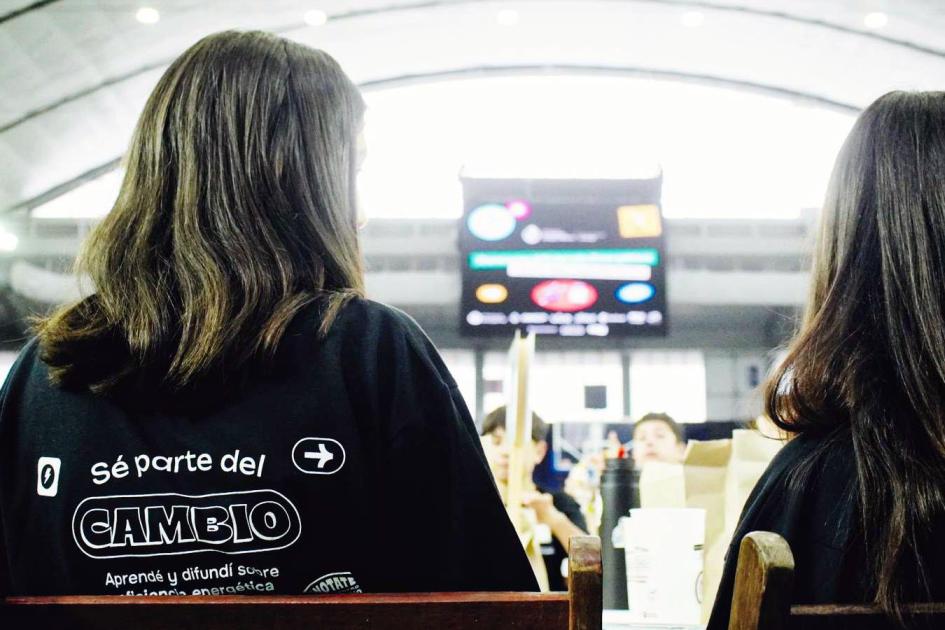 El eslogan de 2024 fue "Sé parte del cambio. Aprendé y difundí sobre eficiencia energética" Dos participantes, vistas desde atrás; su remera dice "Sé parte del cambio"