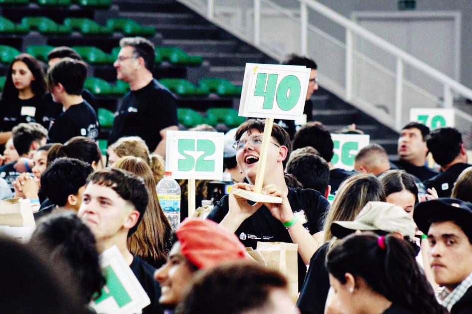 En total, 82 instituciones educativas participaron de esta edición del certamen Grupo de adolescentes; sostienen carteles; detrás, gradas del estadio