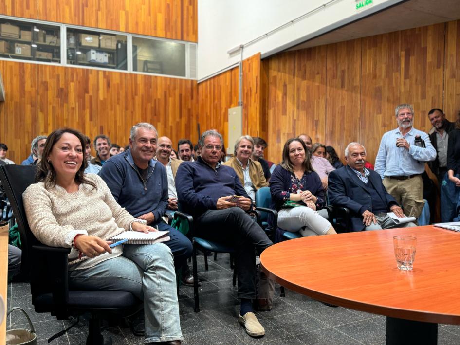 Autoridades presentes en el encuentro. Ministra y autoridades sentados en primera fila; al fondo, público sentado.