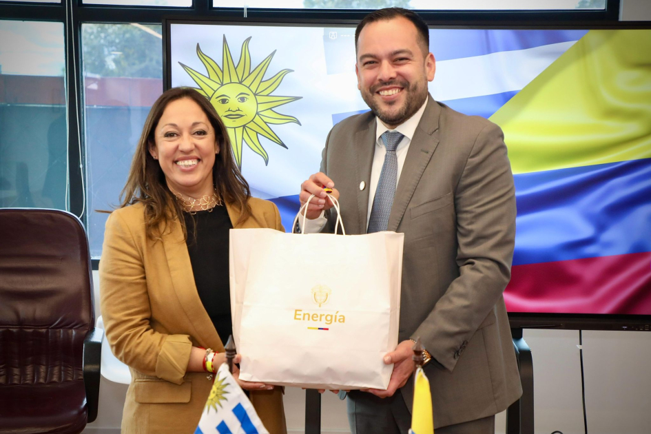 Fernanda Cardona y Edwin Palma Ministra Cardona y ministro Palma sonríen y sostienen un bolso que dice "Energía".