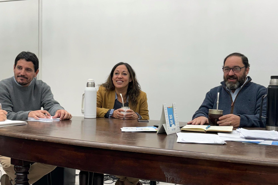Visita a ACIR Cardona, sentada junto a dos hombres tras una mesa