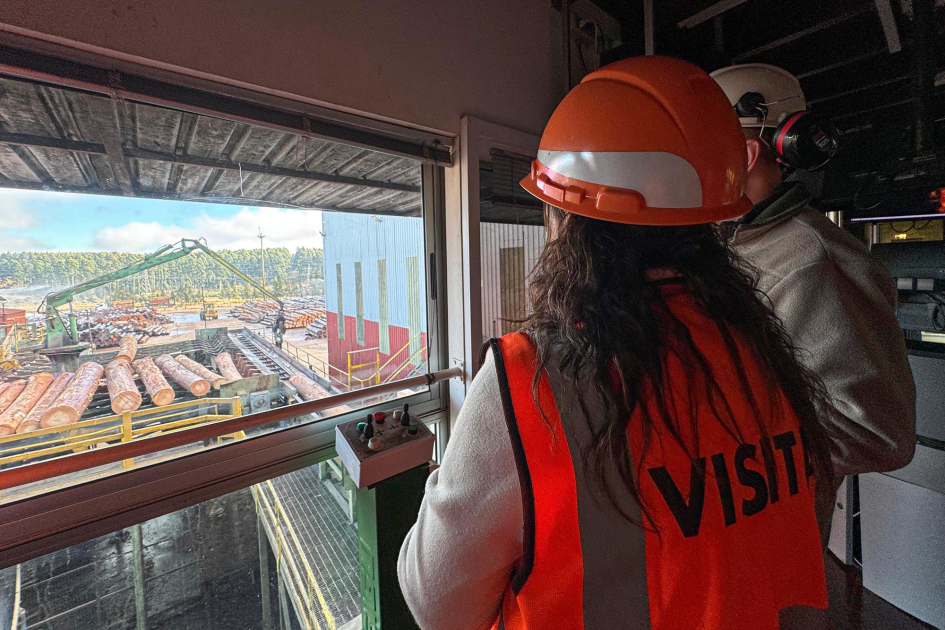 Visita a Urufor Ministra, de espaldas, con casco y chaleco, observa el exterior de la planta industrial de Urufor