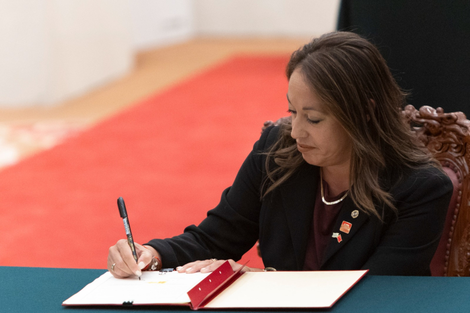 Ministra Cardona sentada firma documento