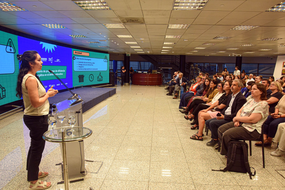 Camila Morales, de la DNE, habla desde atril. Hay público sentado