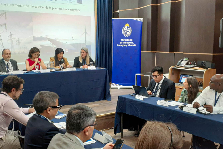 Al fondo, panel en que habla la directora Spinelli; más cerca, personas sentadas en mesas