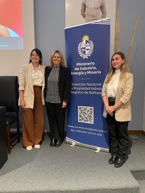 Tres personas paradas junto al banner de la DNPI