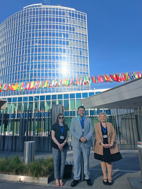 Fernanda Gianfagna, Santiago Montalbán y directora Marianela Delor, en OMPI. Foto: DNPI. Tres personas paradas con las oficinas de OMPI de fondo