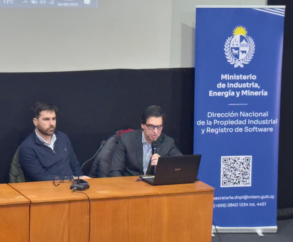 Esc. Bruno Cabrera e Ing. Gabriel Wallusche, DNPI. Foto: DNPI. Dos personas sentadas detrás de una mesa; al lado, banner del MIEM
