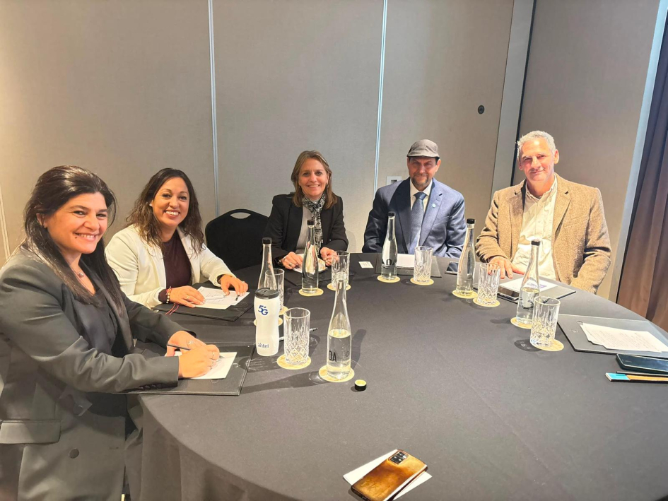 La ministra Fernanda Cardona y la directora Arianna Spinelli, junto a la delegación argentina Personas reunidas en una mesa